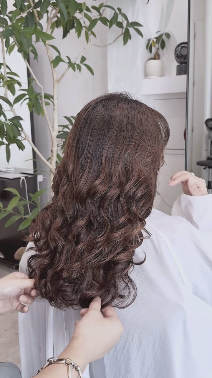 ブラウンのロングヘアに柔らかなウェーブカールをかけた後ろ姿